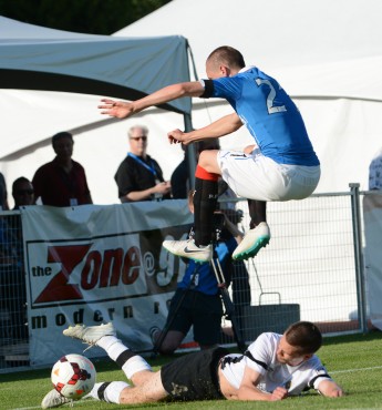 Robbie Crawford of Rangers F.C. leaps over Gavin Barrett of the Victoria Highlanders during a friendly match at Centennial Stadium on July 21.