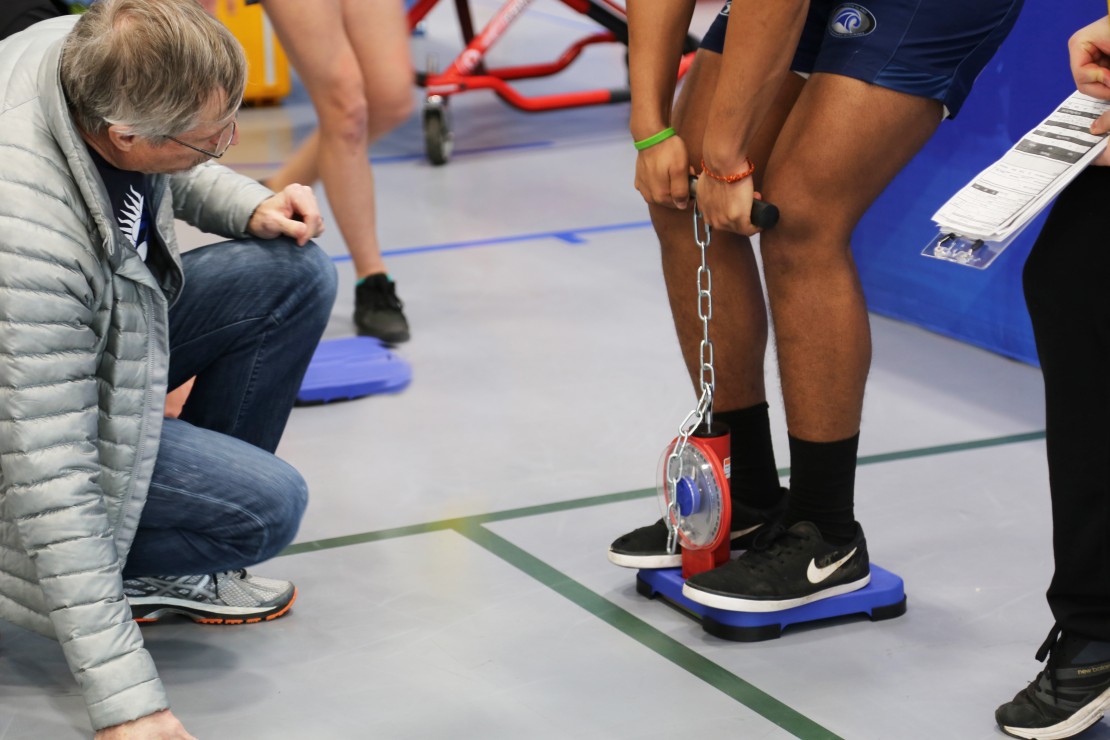 A judge waits to record a contender’s strength test score. Photo by Belle White, Photo Editor