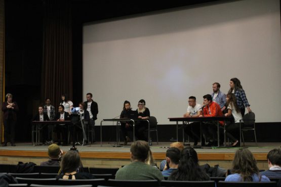 Candidates stand on stage responding to audience questions at the UVSS Election debates