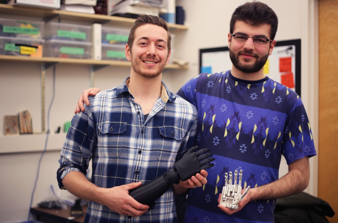 Victoria Hand Project workers Michael Peirone and Sina Valizadeh pose with various prosthetic models.