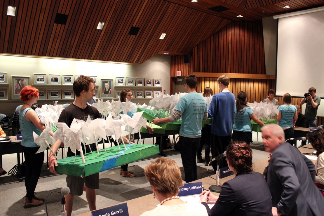 Divest UVic presents the Board of Governors with over 200 handmade wind turbines made from student petitions. Photo by Myles Sauer