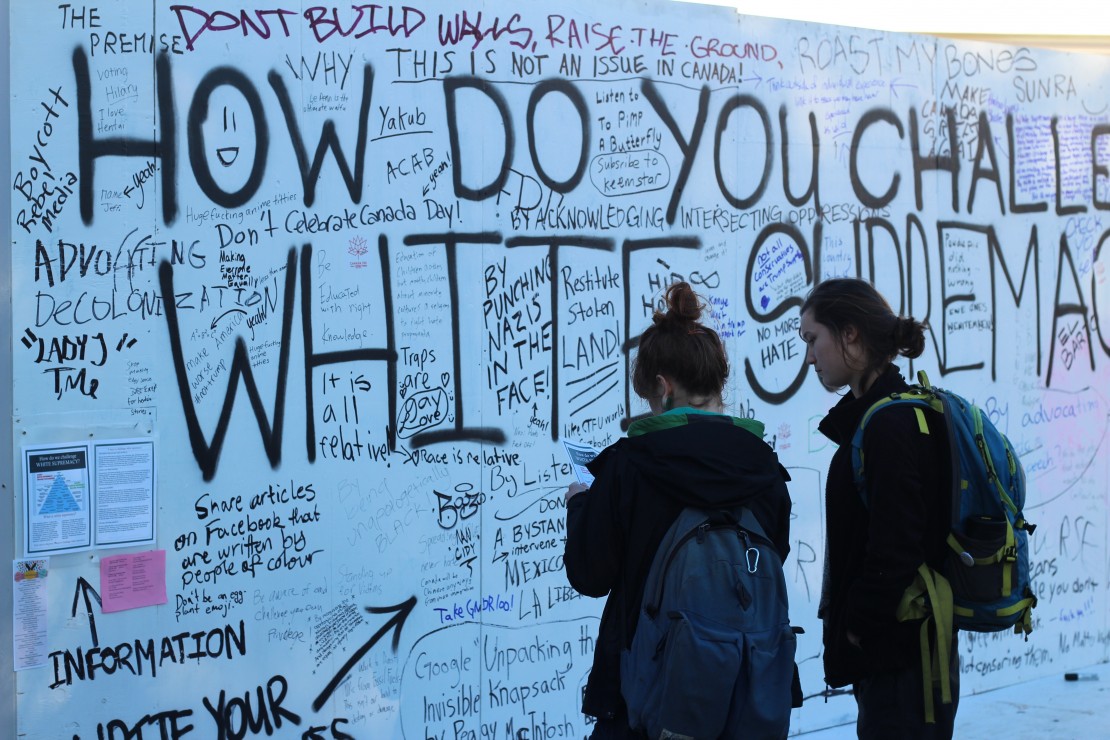Students contemplate the wall early Thursday evening. Photo by Myles Sauer, Editor-in-Chief