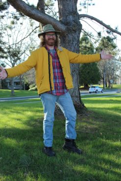 Dirk Slot pictured wearing a hat, yellow coat, plaid shirt, and jeans. He is a UVSS candidate for director for student affairs. 