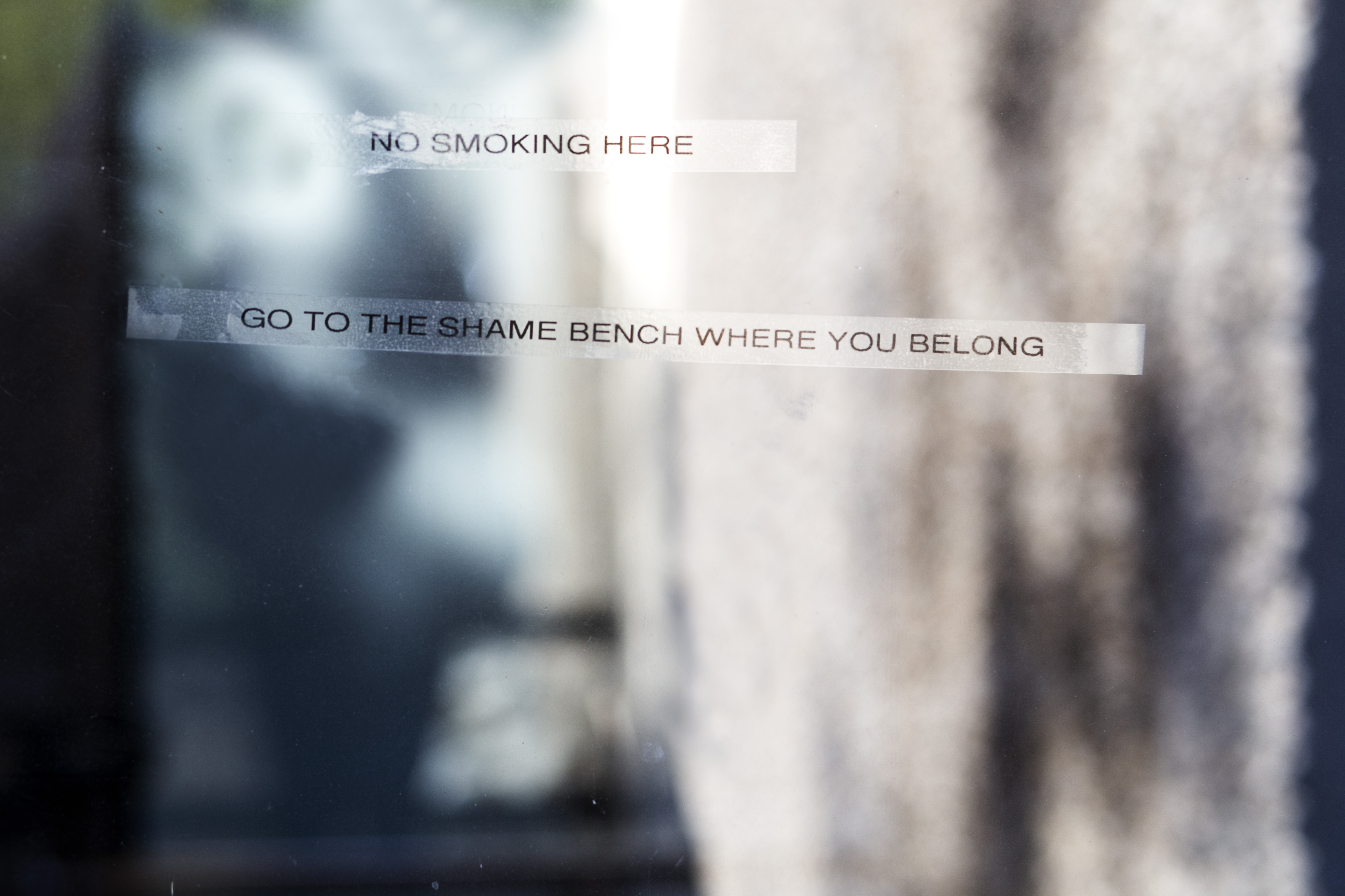 Signs found on campus demand cigarette smokers stick to “shame benches”