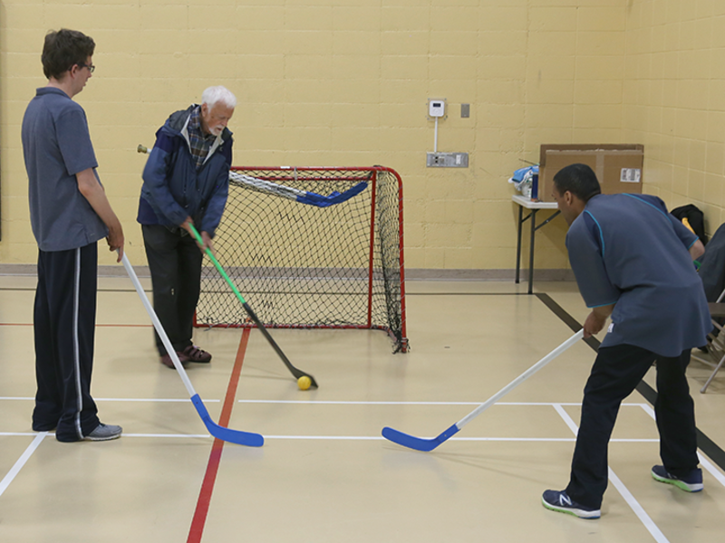 People playing floor hockey. Photo by Brian Gray.