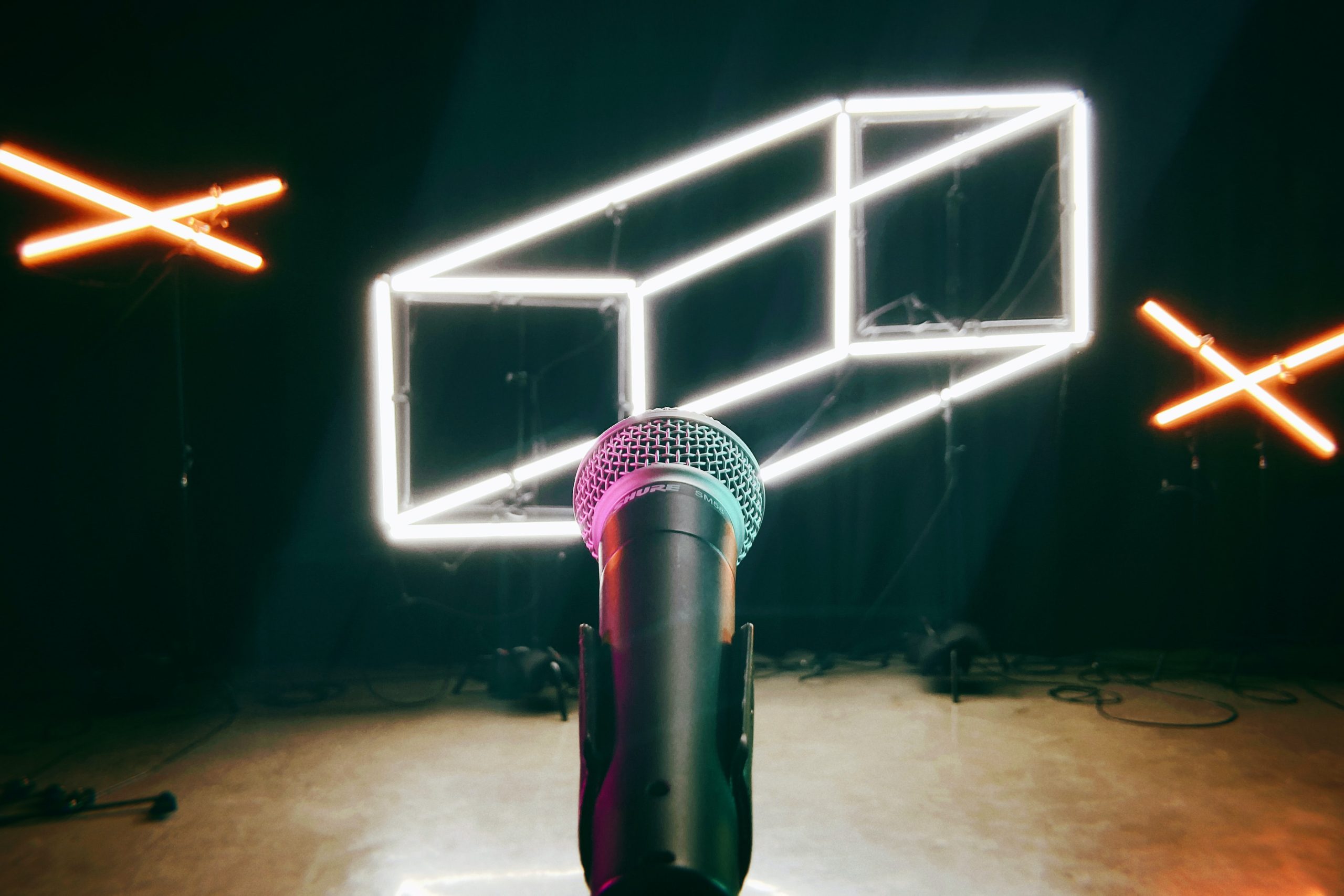 A microphone on a stage, photo by Chad Stembridge via Unsplash.