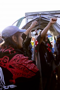 Super InTent City residents raise their fists in solidarity and protest of the government's eviction notice. Photo by Sarah Lazin