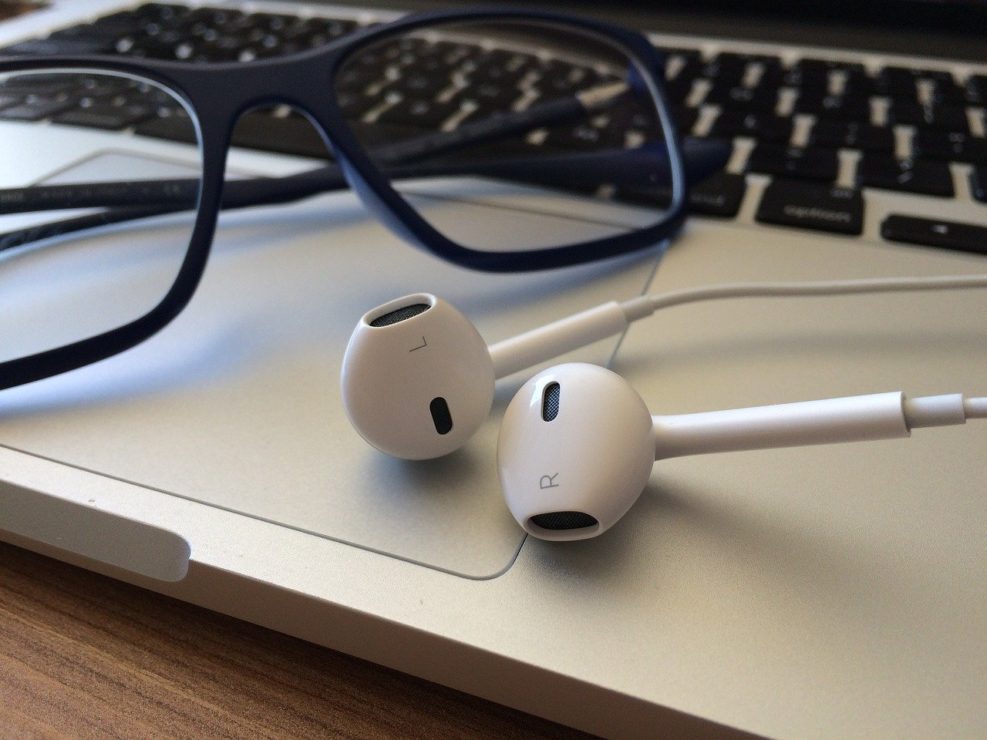 headphones for podcast on computer with glasses