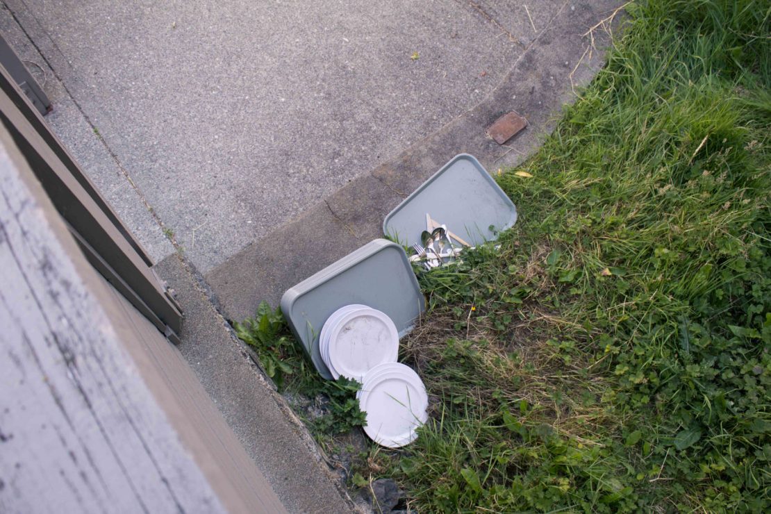 Discarded cafeteria utensils and dinnerware outside the Cluster neighbourhood.