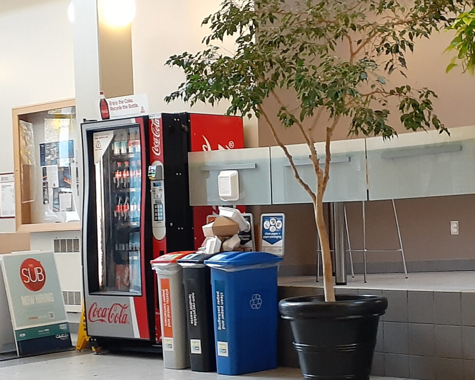 Photo of overflowing recycle bins in the UVic student union building, photo by Sie Douglas-Fish.