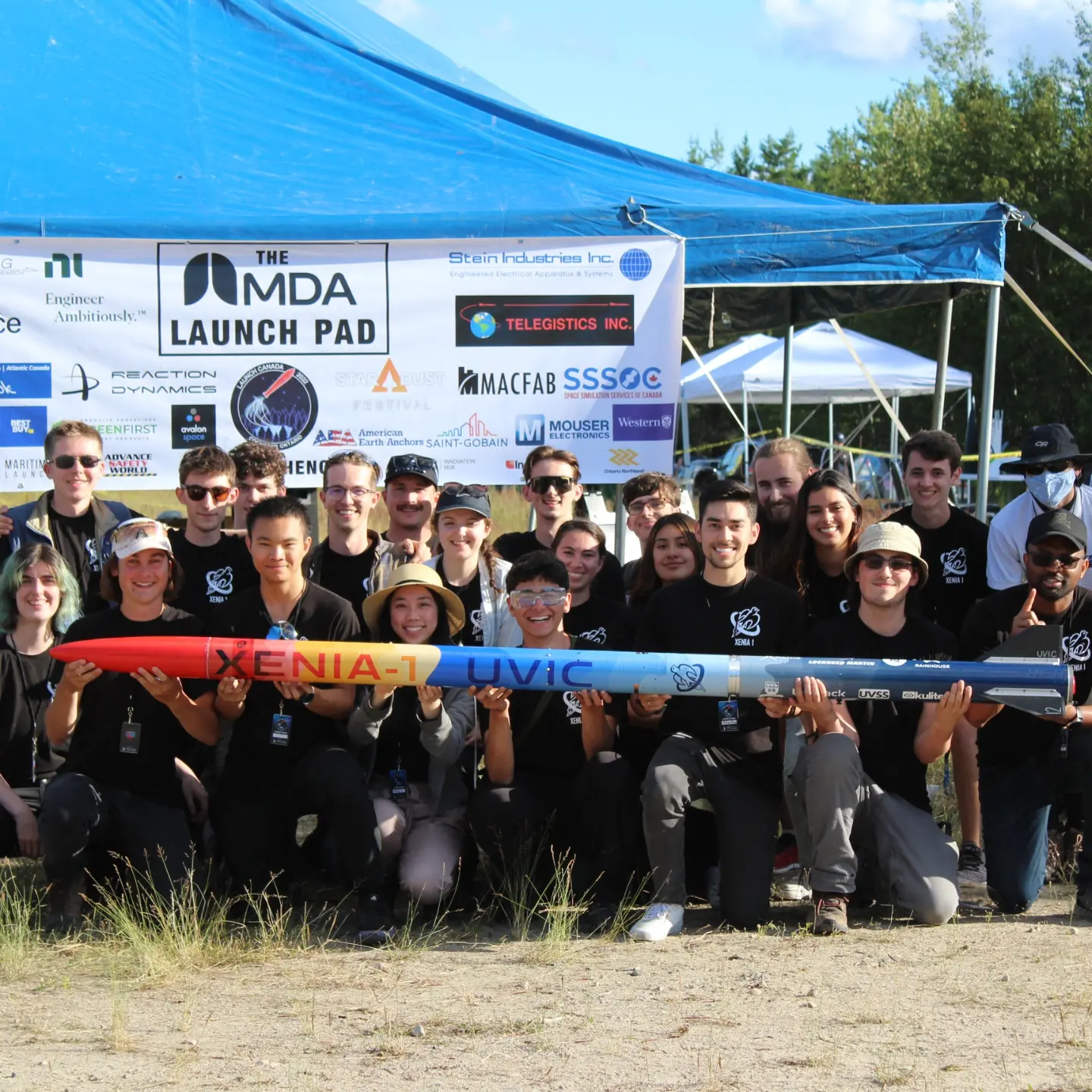 Photo of the rocketry team with their rocket. Provided by UVic Rocketry.