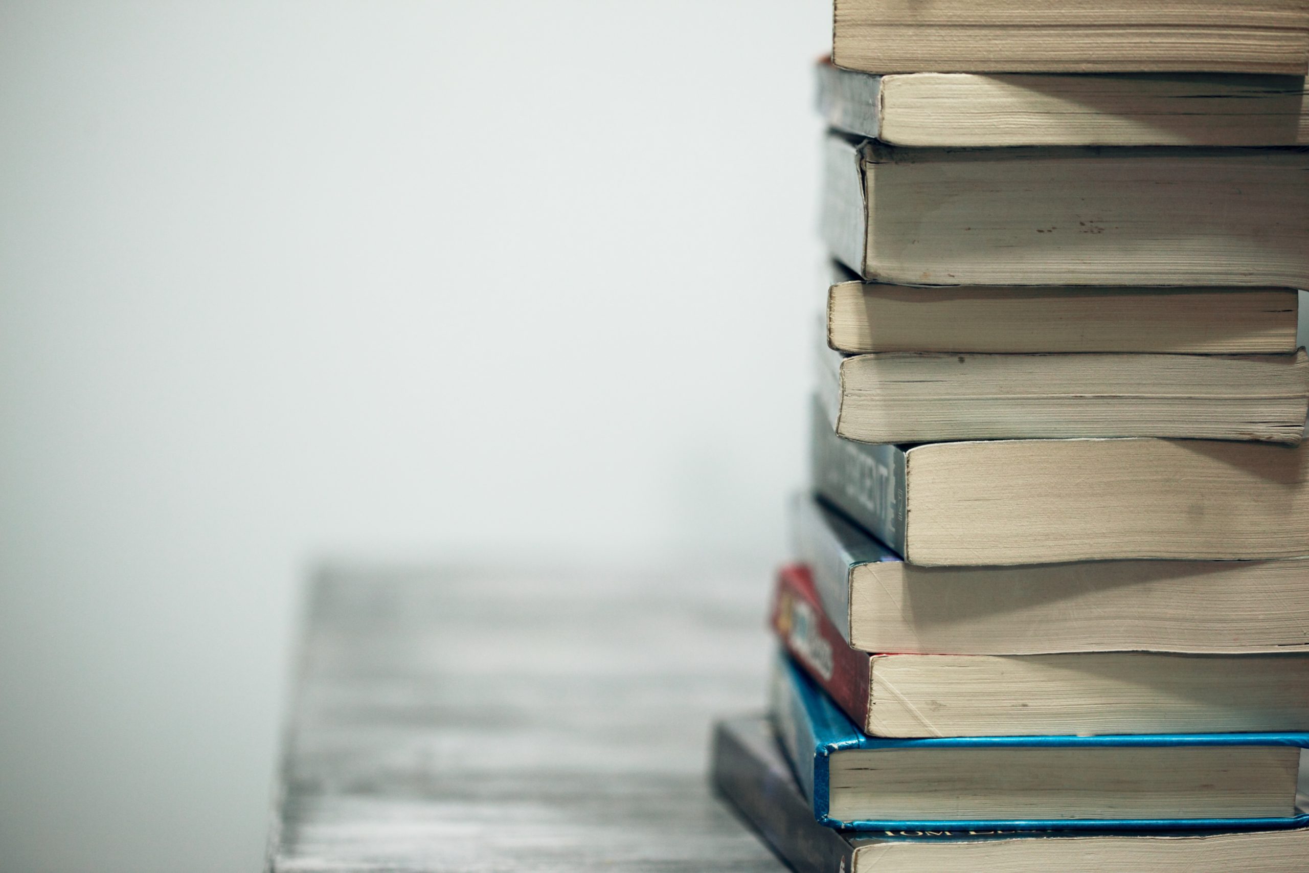 A stack of books, photo by Alexander Grey via Unsplash.
